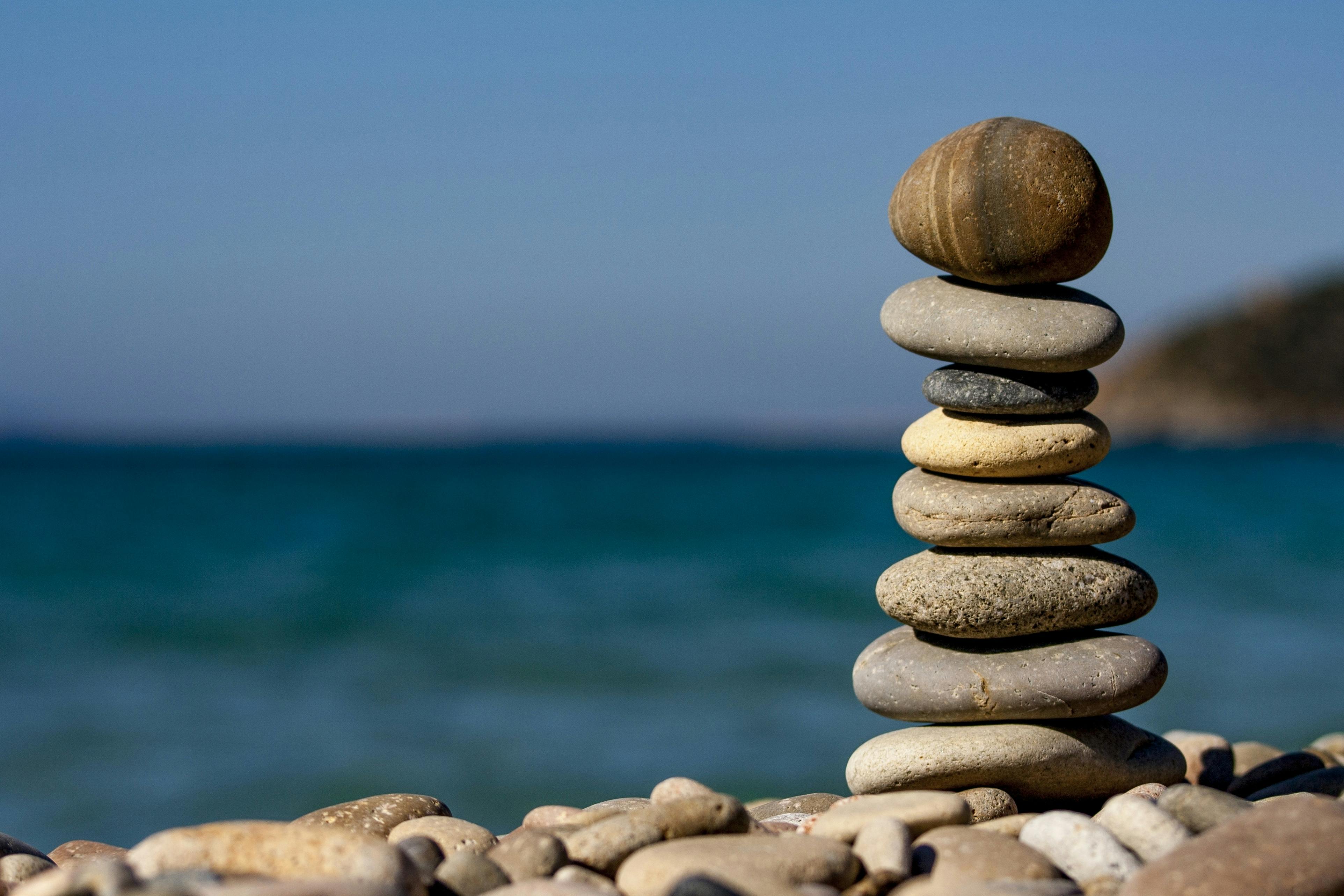 Balanced cairn stones representing neurotechnology research and mindful precision